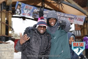 MLK Ski Weekend 2016 two guys in front of banner in the village