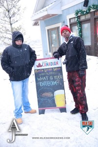 MLK Ski Weekend 2016 two gys posing in village in front of one of the bar advertisements